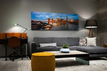 a living room with a gray couch and a painting on the wall